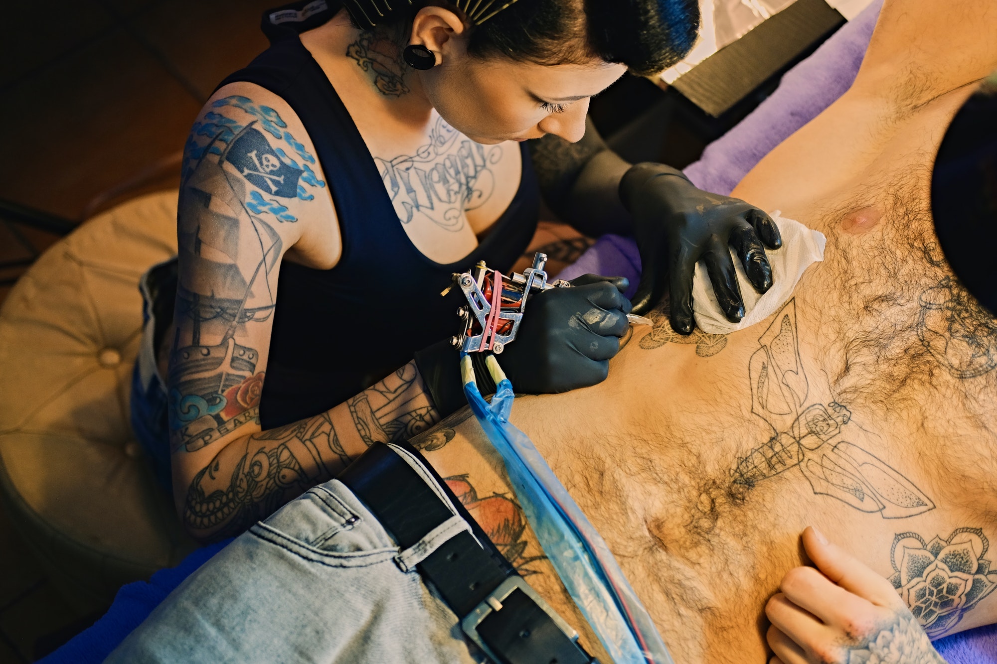 image-of-female-tattoo-artist-makes-a-tattoo-on-a-man-s-torso-.jpg